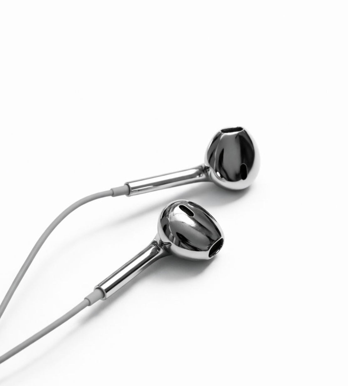 A pair of glossy chrome silver wired earbuds with a light gray cable, shown on a clean white background.